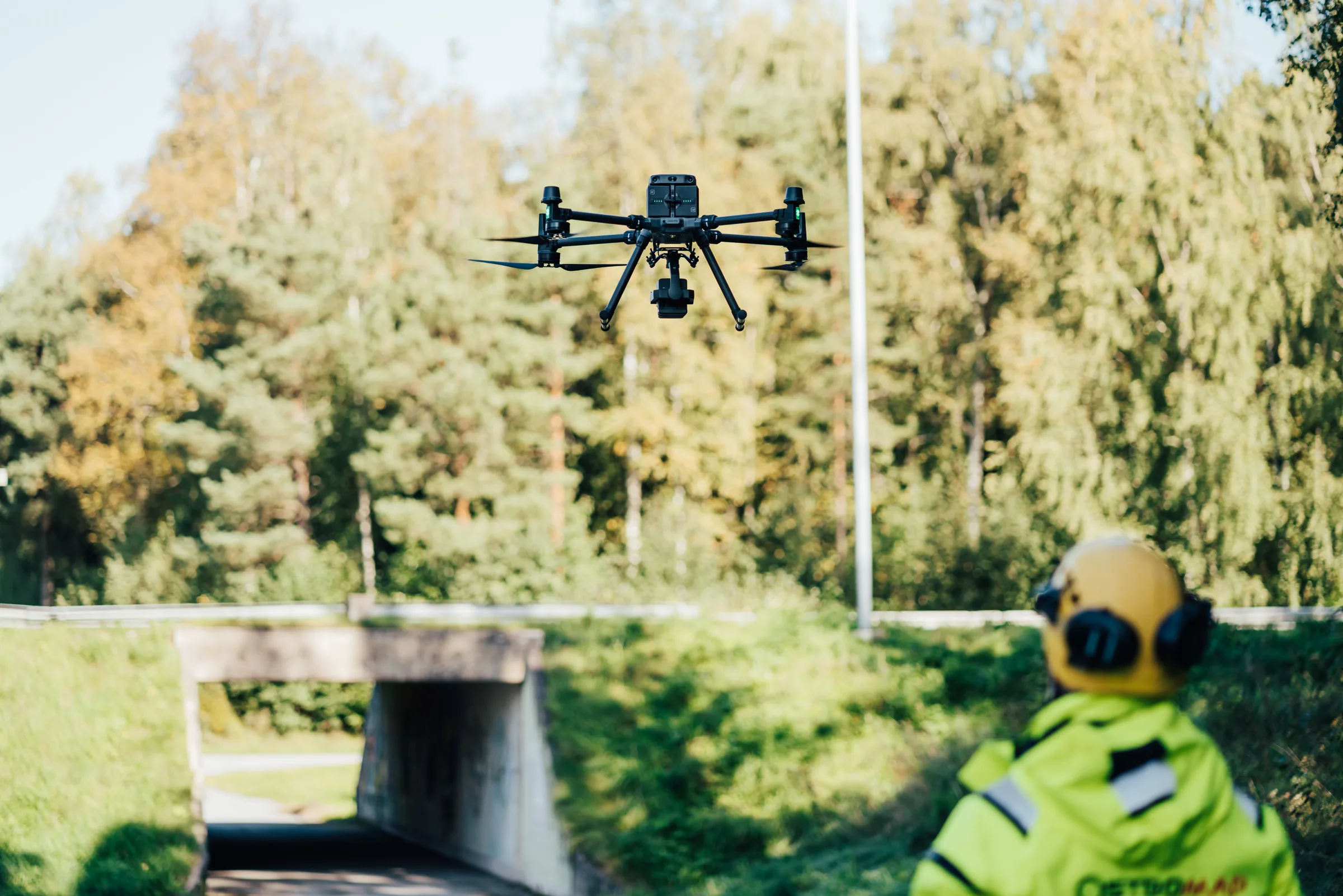 Drönarpilot med hörselskydd flyger en LIDAR-drönare